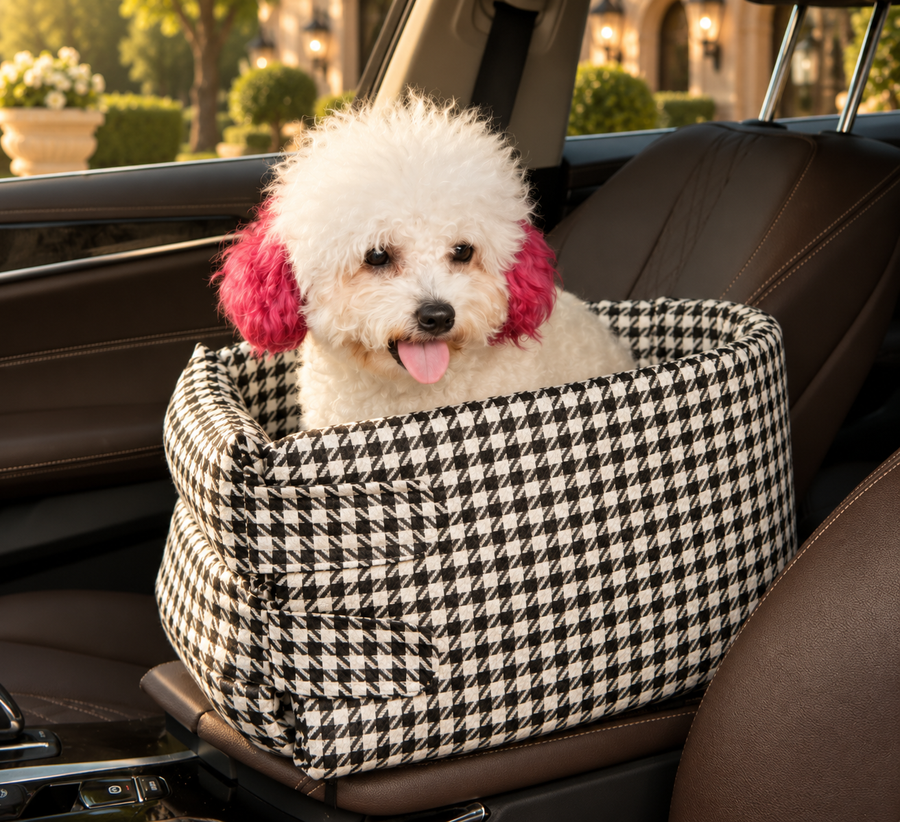A small white dog settled in a houndstooth travel bed inside a car