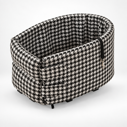 The black and white houndstooth travel bed on a plain background, with the tether clip hanging inside