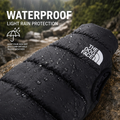Black puffer jacket with rain protection features on a rocky background