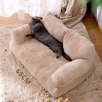 Gray cat lounging on a plush beige pet sofa bed with raised armrests, shown on a soft rug in a sunlit room. The pet couch measures 65 cm wide and provides comfortable support for cats and small pets. | Pet Grooming | Pet Supplies and Food Australia | Pet Supplies Sydney | PetNexa Australia | Shop now